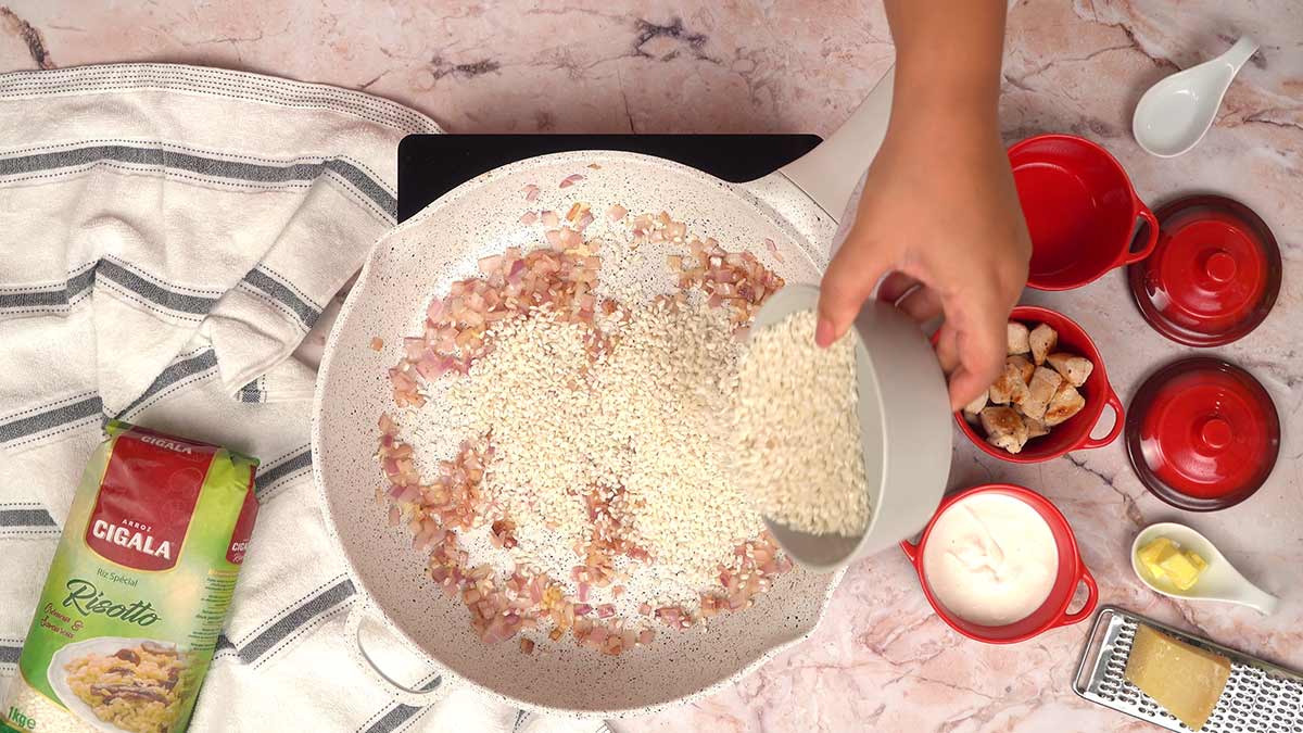 Ajout du riz spécial risotto Arroz Cigala au mélange de l'oignon et l'ail