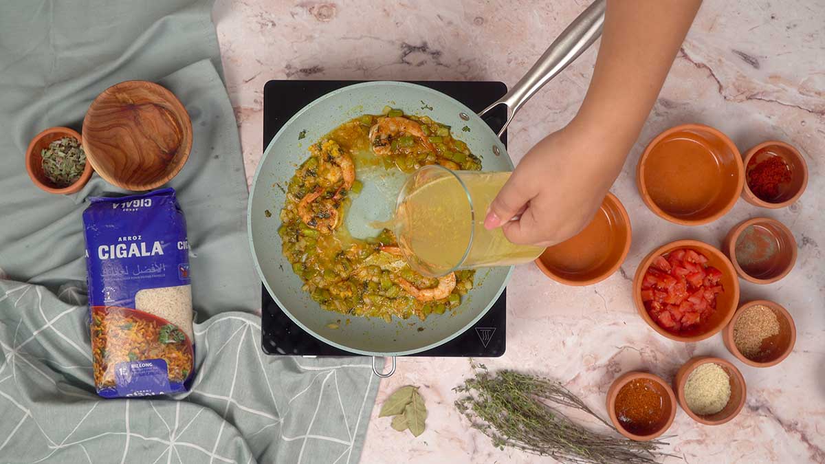 Ajout du bouillon au mélange de crevettes, légumes et farine