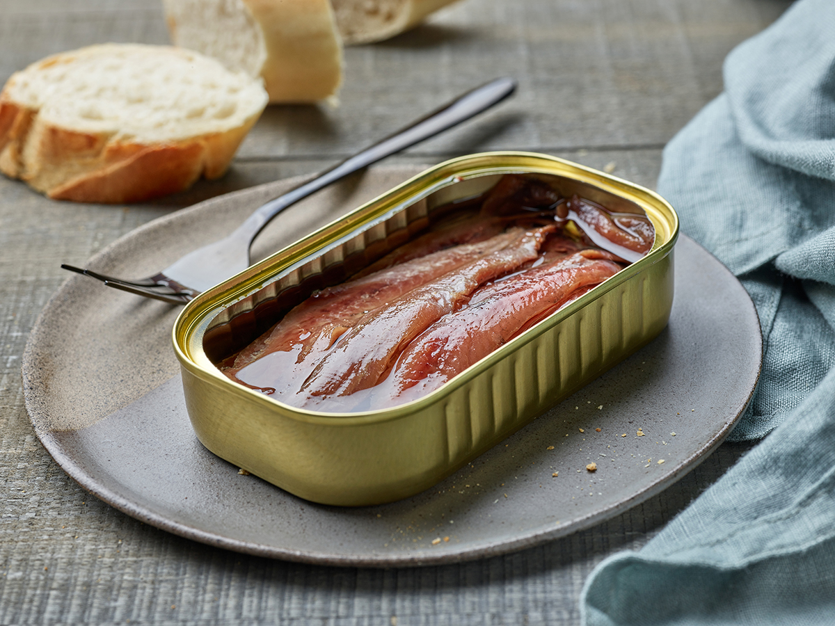 Boite d'anchois en conserve accompagné de morceaux de pain