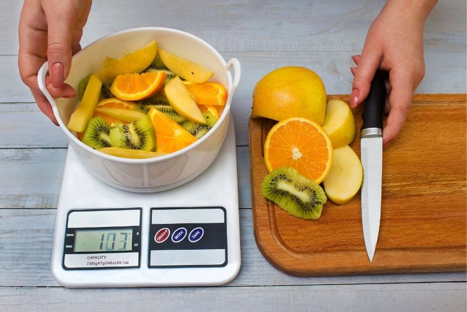 une personne en train de peser les fruits découpés en morceaux